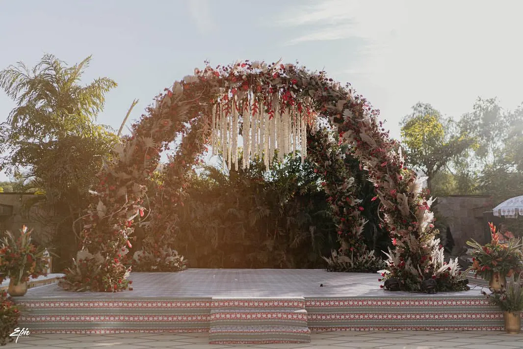 For the love of timeless elegance. We brought a Sabyasachi-inspired vision to life with a dramatic arch of deep reds, dried florals, and a stunning chandelier of tuberoses, creating a mandap that felt both royal and deeply romantic.
