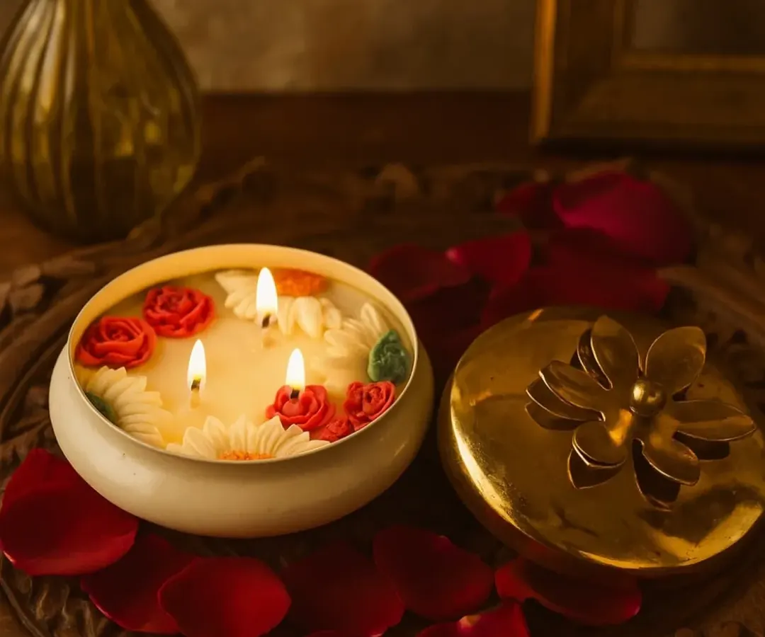 My Timeless Urli Candle, lit and glowing. The three wicks create a warm, inviting ambiance, while the hand-crafted wax roses and daisies add a touch of elegance. It’s perfect for festivals or making any evening feel special.