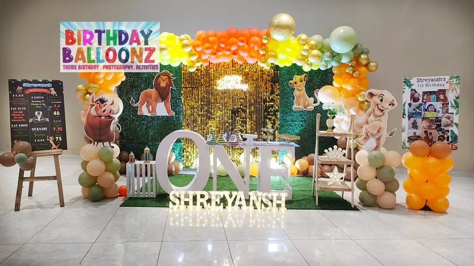 I designed this entire Lion King theme setup for a first birthday party. It features a lush green backdrop, a sparkling sequin panel, character cutouts of Simba and his friends, and large marquee letters spelling "ONE" to create a complete photo-ready stage.