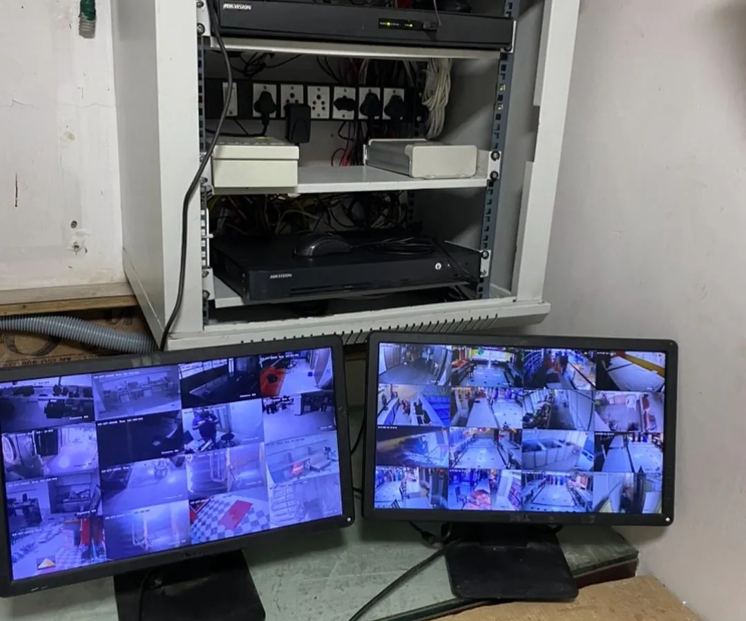 Here is the end result of a professional network and CCTV installation. We organize all essential hardware, including NVRs and network switches, into a clean, wall-mounted server rack, with dual monitors set up for comprehensive security camera monitoring.