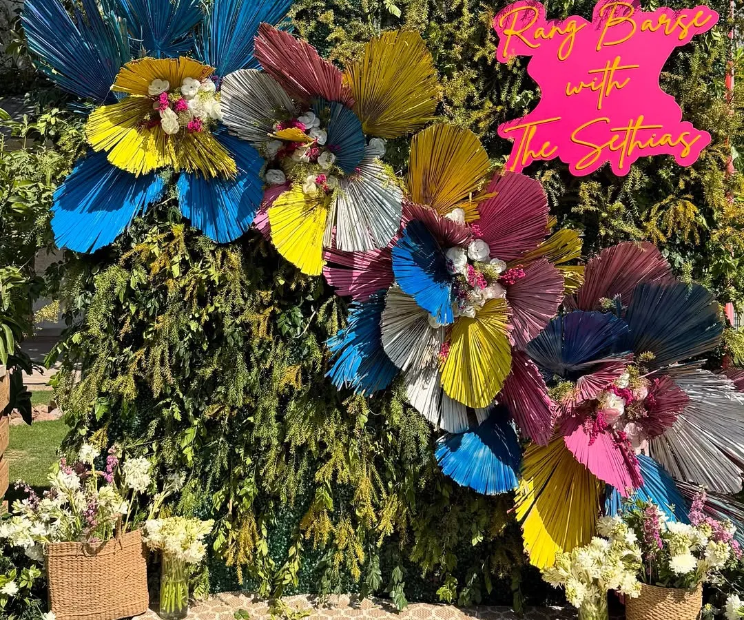 We love bringing a modern, playful twist to traditional festivals. For this Holi party, we designed a vibrant photo backdrop using colorful dried palm leaves and fresh flowers, creating the perfect spot for guests to capture the joy of the celebration.