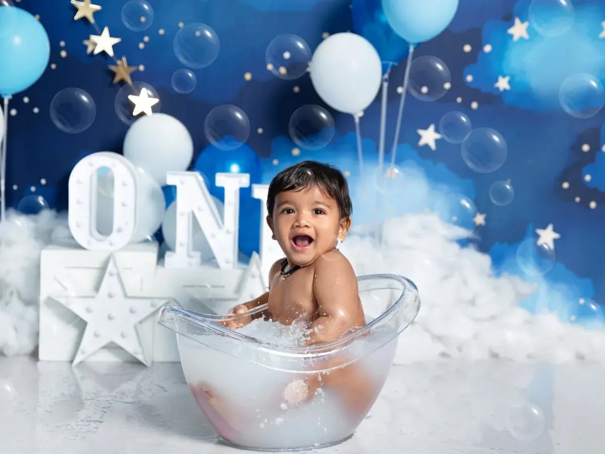 Pure joy during a first birthday bath splash! This add-on session captures the happiest moments as your baby plays in the water against a dreamy, starry night backdrop.