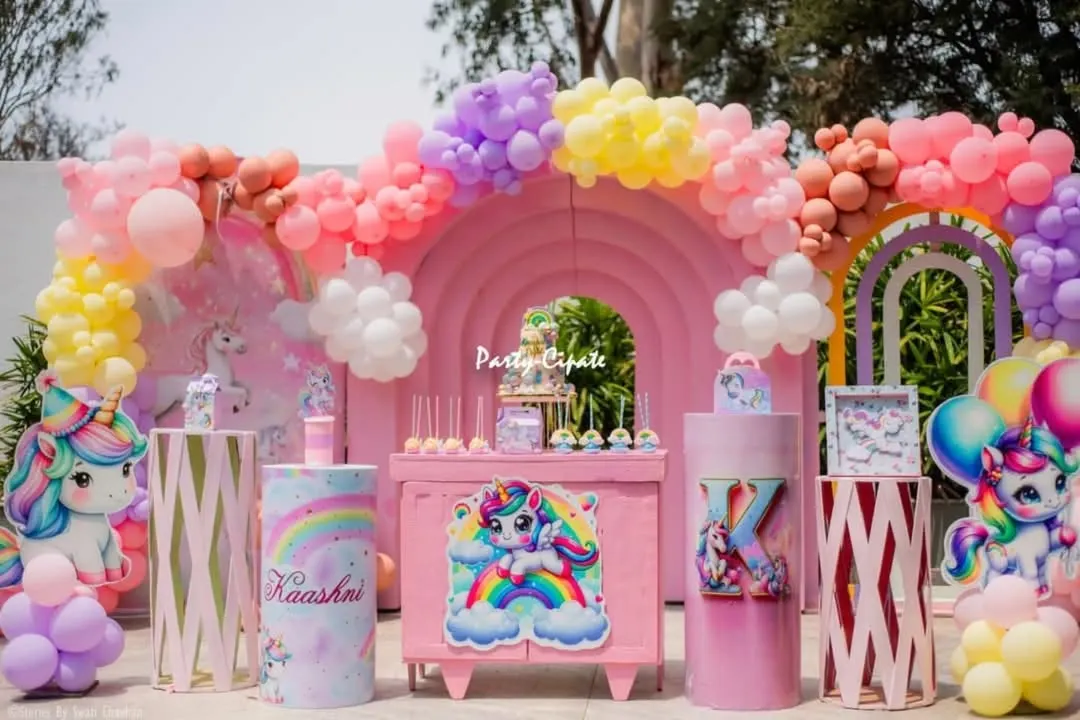 For Kaashni's unicorn party, we created a complete dreamscape in pastel pinks, purples, and yellows. The setup features a rainbow balloon arch, custom character cutouts, and themed pedestals for the cake and desserts, making it a perfect photo backdrop.