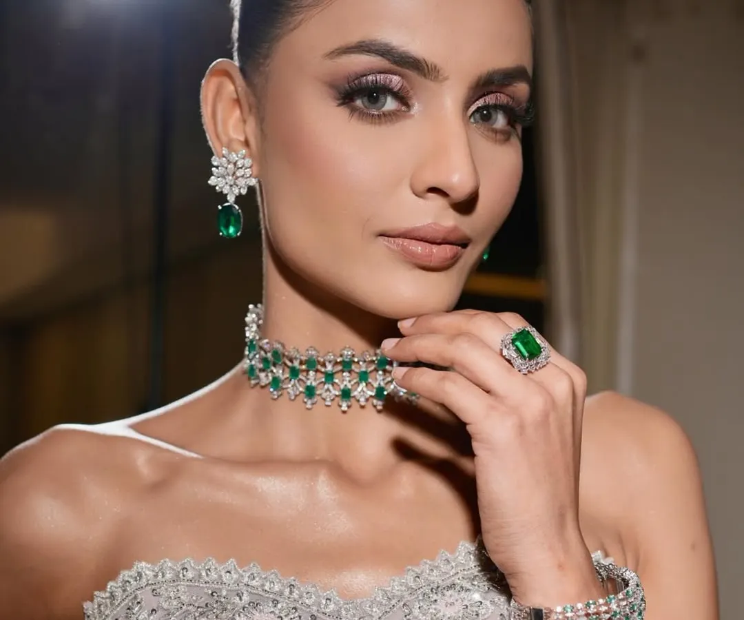 This is modern elegance with an edge. I created this sculpted glam look with shimmering silver and lilac eyeshadow, flawless skin, and bold brows, perfectly complemented by a stunning emerald and diamond choker for a high-fashion, reception-ready finish.