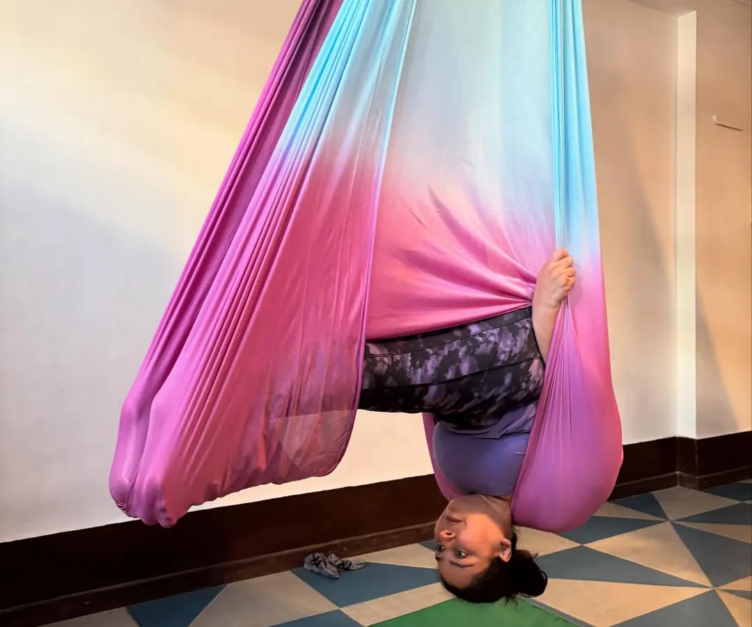 Look at that smile. This is what it feels like to trust the hammock and see the world from a new perspective. This supported inversion helps decompress the spine and feels absolutely wonderful.