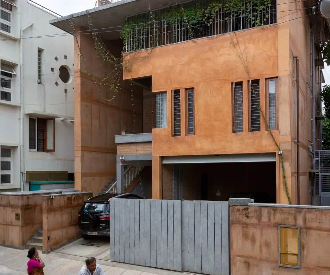 This is the exterior of a residence we designed in a dense Bangalore neighborhood. We used earth from the site itself and debris from the old, demolished house to construct the new walls, creating a structure that is both modern and deeply rooted in its own history and place.