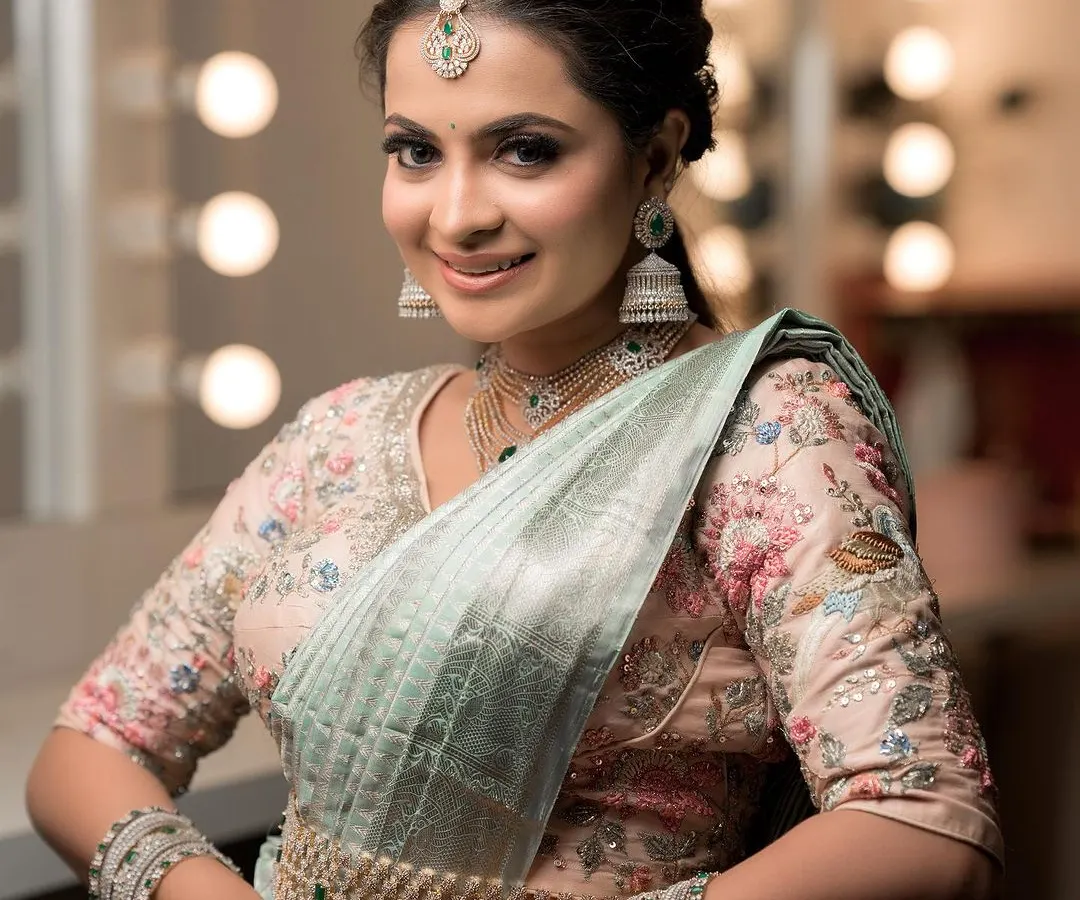 For receptions or modern events, I offer stunning American Diamond sets like this one. This multi-layered necklace, paired with a delicate maang tikka and matching jhumkas, provides exceptional sparkle and is designed to complement contemporary sarees and gowns beautifully.