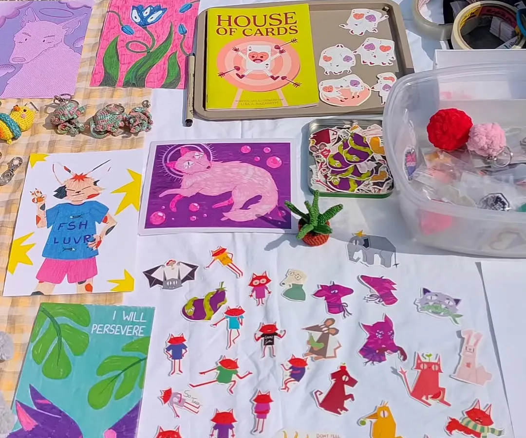 Here's a look at how my digital doodles become physical art you can own. This setup shows a collection of my whimsical wall art prints, a variety of indie illustrated stickers, and my self-published zine, "House of Cards." It’s so fun seeing them all together.