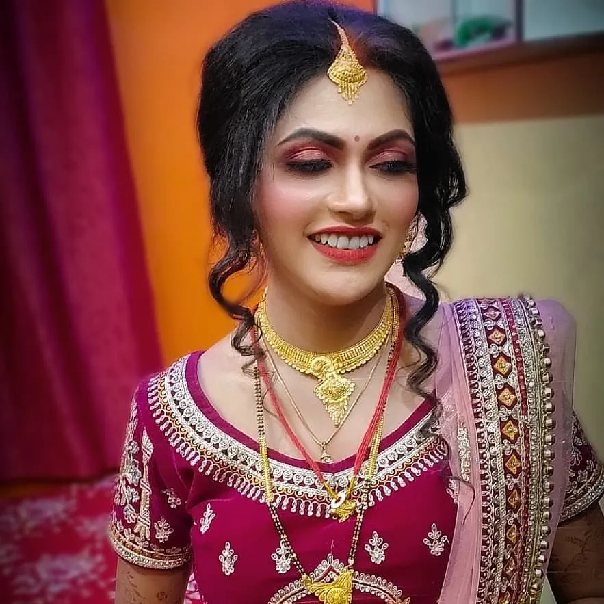 A radiant smile on a happy bride! I created this classic bridal look with bold red lips and defined eyes, complemented by a soft curly updo to complete her wedding day style.