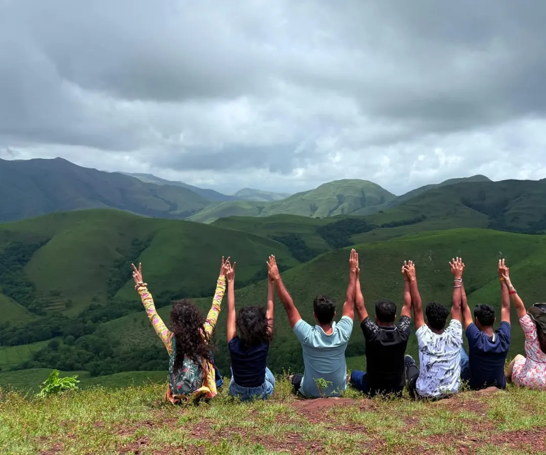 This is what pure happiness looks like. A moment of joy with fellow trekkers on the rolling grasslands of Kudremukha, with a massive view of the mountains behind us.