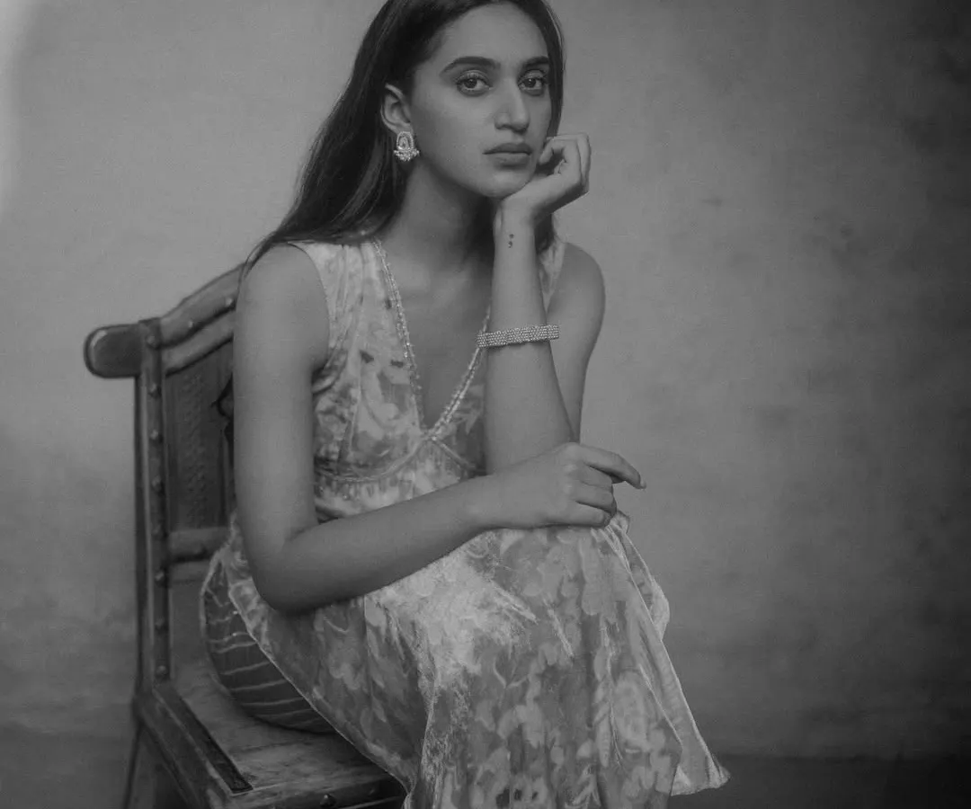 A seated portrait for a PhotoVogue feature, shot on film to achieve a timeless and classic look. The use of natural light and shadow creates depth and mood, ideal for editorial photography.