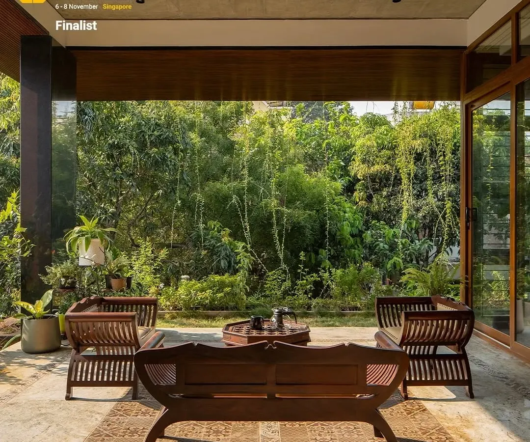The covered patio of our "A Home by the Park" project serves as a tranquil transition space. We used traditional wooden seating and patterned flooring to create an inviting outdoor lounge that feels like a natural extension of the home, perfect for enjoying the surrounding greenery.