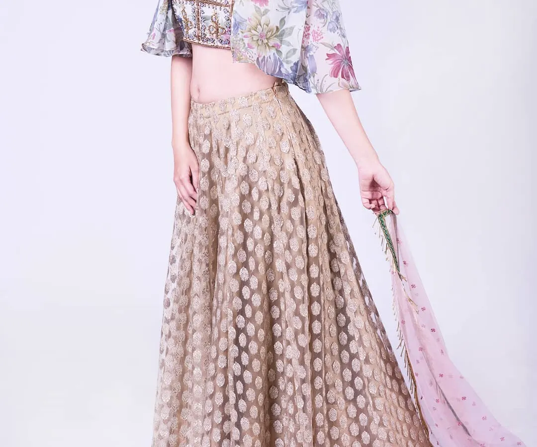 For a modern twist on festive wear, I designed this light organza lehenga set. It features a beautifully embroidered crop top with delicate floral patterns and contemporary cape sleeves, perfect for a sangeet or cocktail event.