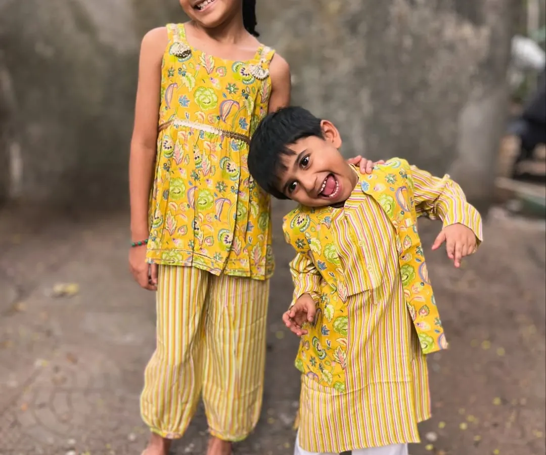 Sunshine in an outfit! This is one of my favorite sibling twinning sets, featuring a bright yellow floral print on a comfy kurta-bandi set for him and a matching top with striped pants for her. I design these so kids can run, jump, and give the best hugs without any fuss.