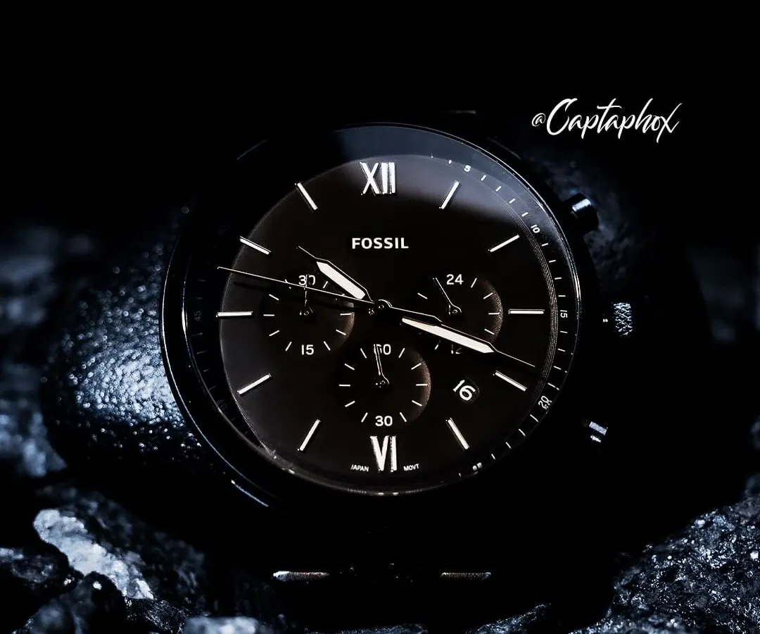This is a dark and moody concept shoot for a Fossil watch. I placed the timepiece on textured, dark rocks to create a rugged, masculine aesthetic. The lighting is carefully controlled to catch the watch hands and markers, highlighting the fine details of the dial against the dark background.