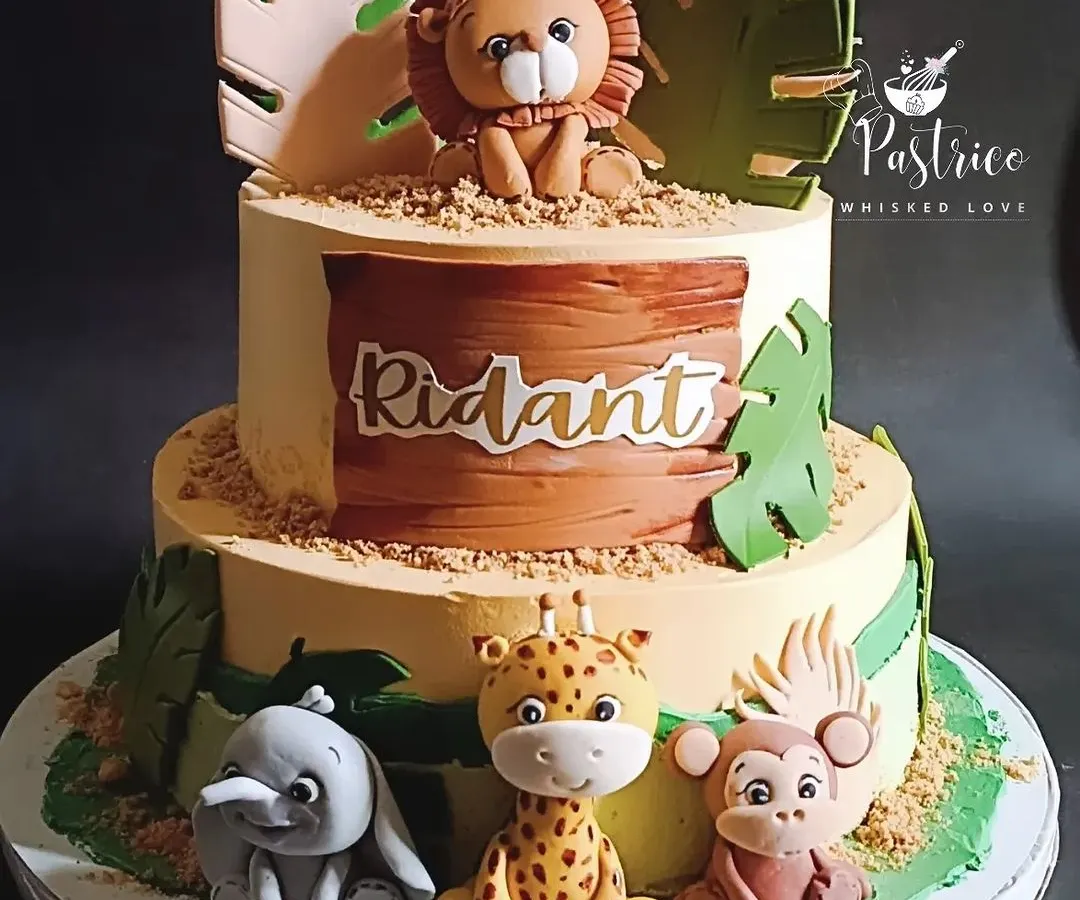 I love creating adorable jungle-themed cakes for little ones. This two-tiered chocolate cake features handmade, edible fondant animals like a lion, giraffe, and elephant, perfect for a wild first or second birthday party.