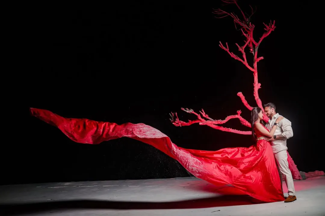 For our pre-wedding shoots, we create magic. This shot uses a dramatic red fabric against a dark backdrop to create a powerful, artistic image that tells a story of passion and connection. It’s a perfect example of our creative pre-wedding photography.