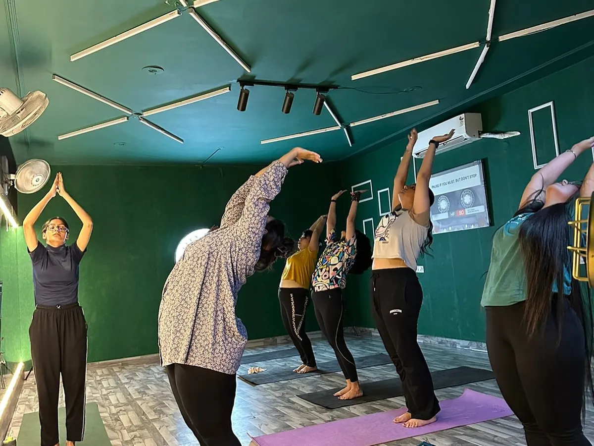 Finding balance and strength in our group yoga class. Here, our members are practicing a standing backbend, or Anuvittasana, to improve posture and flexibility. Our certified instructor ensures everyone maintains proper form for a safe and effective stretch.