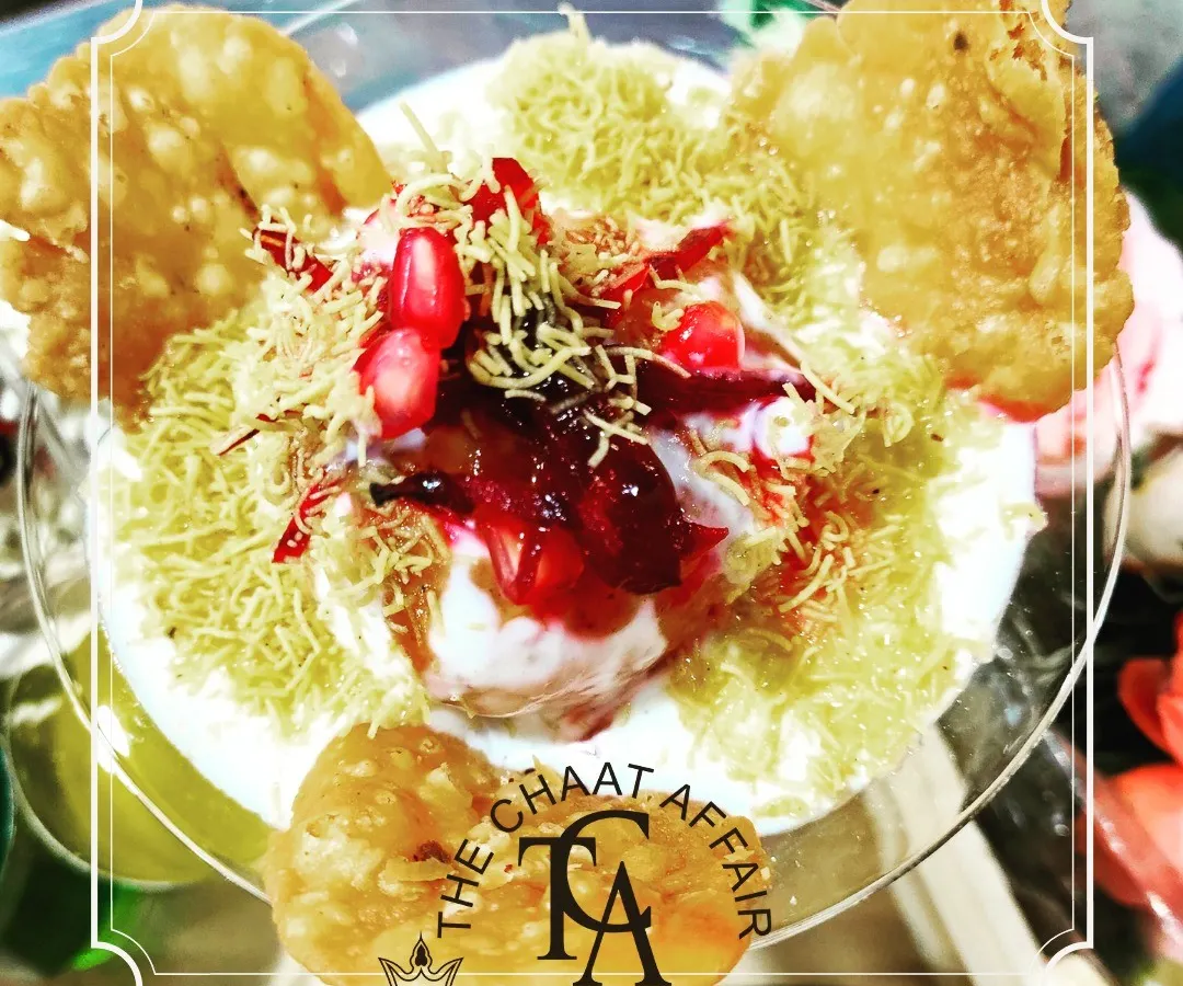 We present classic Bhalla Papdi as a work of art. Served in a crystal glass, each layer is carefully constructed with creamy yogurt, tangy chutneys, crisp papdi, and a garnish of fresh pomegranate, transforming a beloved street food into a gourmet delight.