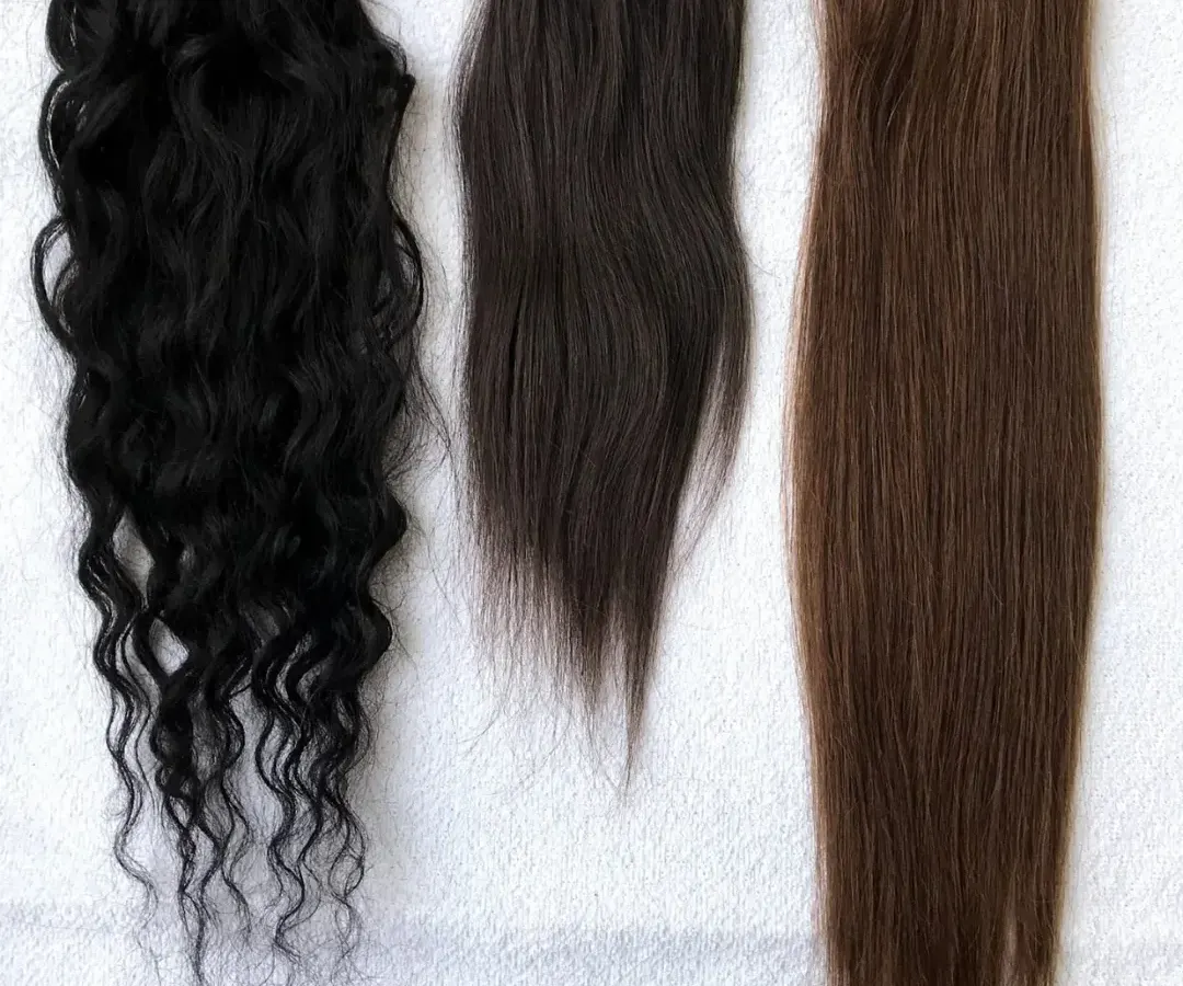 I offer a wide range of textures and colors to ensure a perfect match for every client. This image displays some of my most popular options, including natural black curly, dark brown wavy, and straight light brown extensions.