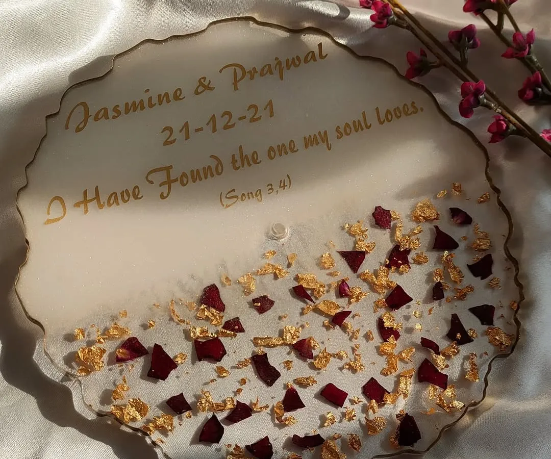 I love making personalized engagement platters. This one features the couple's names, their special date, and a meaningful quote, all surrounded by preserved rose petals and gold flakes for an elegant touch.