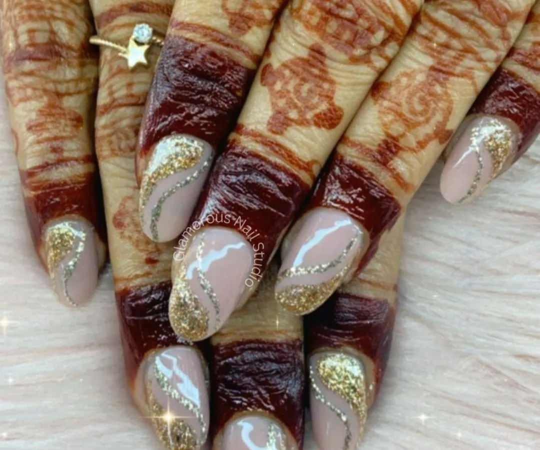 We absolutely love creating the perfect nails for our brides. This design features a dazzling gold glitter that fades into a soft nude base, accented with delicate silver swirls. It’s the perfect complement to intricate mehndi, creating a look of pure festive elegance.