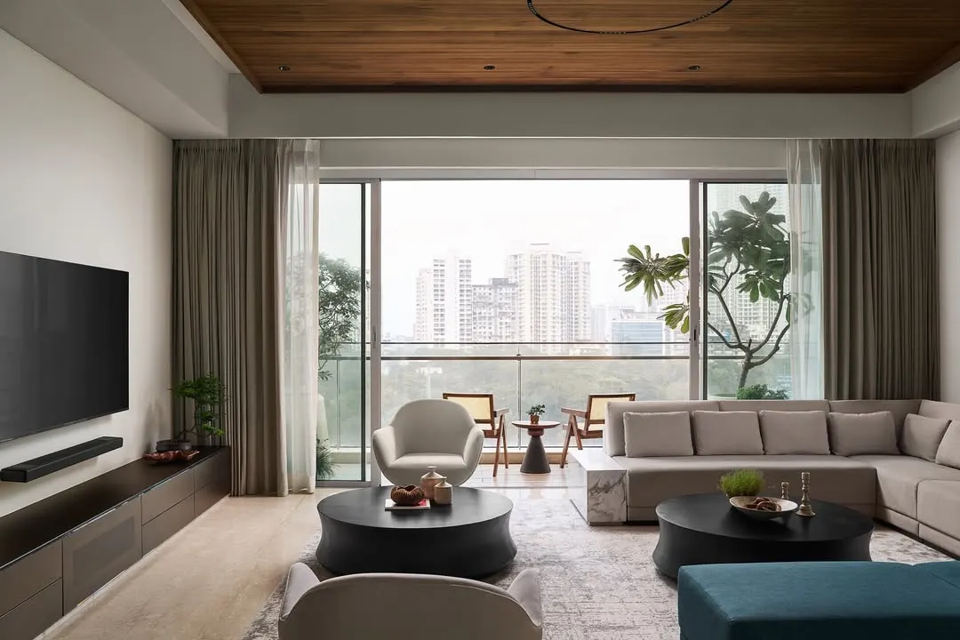 The living room of Lumen House is designed to be an urban retreat, where a warm neutral palette and a natural wood ceiling create a foundation of comfort. The space opens onto an expansive balcony, blurring the lines between indoors and out and flooding the room with natural light.