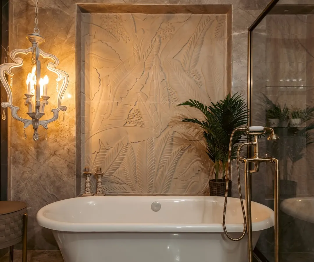 I believe a master bathroom should be a private retreat. Here, a classic clawfoot tub is set against a backdrop of textured stone and marble, with ornate brass fixtures and a statement chandelier adding a layer of opulence. It is a space designed for indulgence and tranquility.