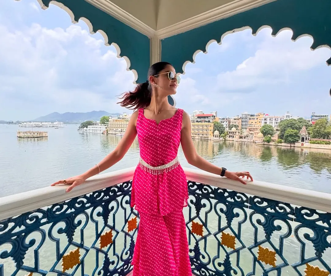 Styling for a vacation is about matching the energy of the place. For this trip to Udaipur, I chose a vibrant pink bandhani co-ord set that felt both festive and modern. The peplum top and tiered pants, paired with a traditional silver belt, created a look perfect for exploring the city's beautiful architecture by the lake.