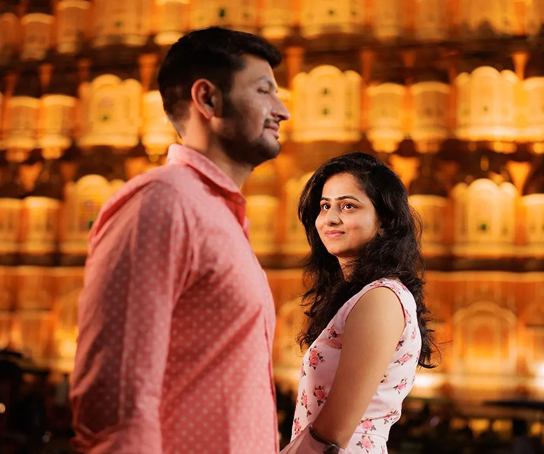 We captured this moment against the iconic Hawa Mahal in Jaipur, its golden facade glowing at night. This shot embodies the royal romance and timeless elegance that a destination pre-wedding shoot in the Pink City offers.