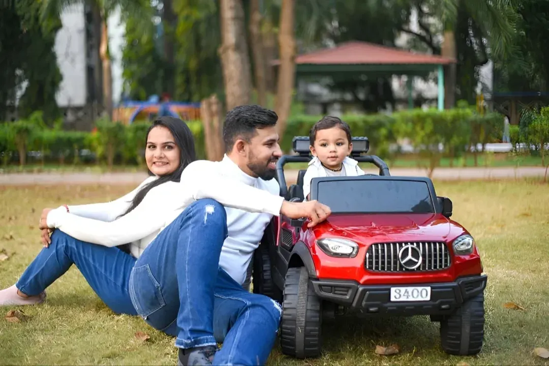 A perfect family moment captured outdoors. I focus on natural interactions to create relaxed and happy family portraits, like this one with parents and their little one enjoying a day in the park with his new toy car.