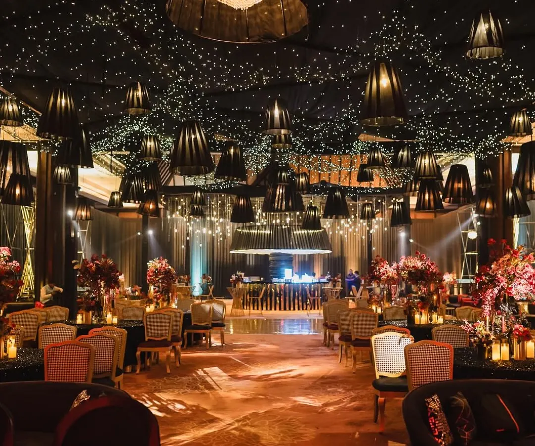 We believe in making weddings cinematic. For this Udaipur sangeet, we designed a starry night ceiling with hundreds of fairy lights and dramatic black lampshades, creating a moody, romantic, and utterly unforgettable ambiance for a night of celebration.