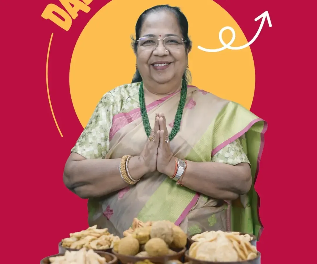 Meet Dadisaa, the heart and soul of our kitchen. She is just like your own dadi, pouring her love and years of experience into every recipe. In front of her is a spread of her signature creations, from crispy mathri to wholesome laddoos, all waiting to bring a taste of home to you.