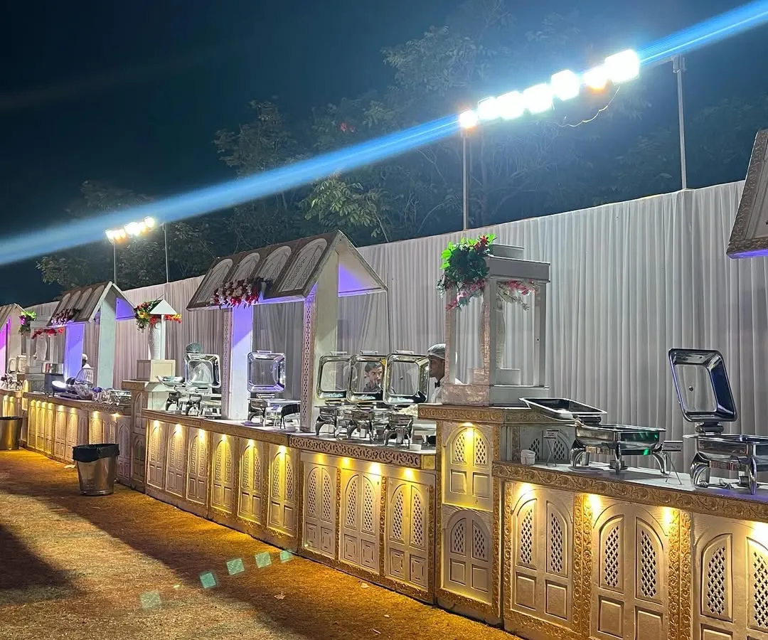 This is a look at one of my full-scale outdoor buffet setups. I use custom-built counters with elegant carvings and warm lighting to create a grand and inviting dining experience that complements the celebration, no matter the size of your guest list.