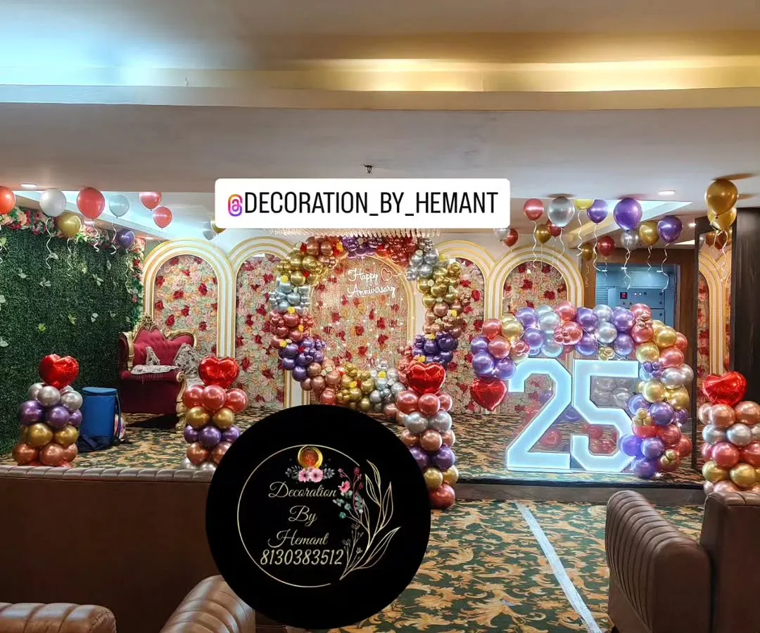 For a grand 25th wedding anniversary, I transformed this hall into a spectacular celebration space. The setup includes a large stage with multiple arches, a custom ring backdrop, and a lit marquee number, all tied together with a vibrant balloon arrangement.