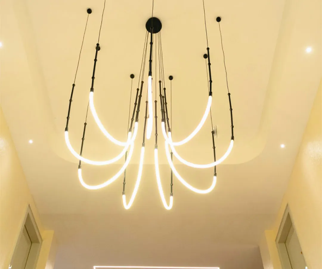 For this modern home in Guwahati, I designed a dynamic, sculptural LED chandelier to cascade through the double-height space above the staircase. It's not just a light fixture; it's an architectural statement that draws the eye upward and fills the home with a contemporary, artistic energy.
