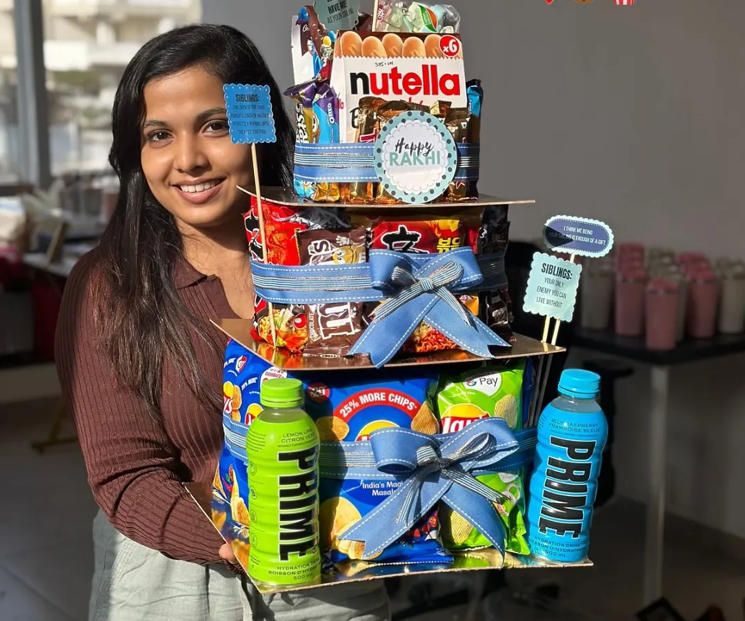 Here I am with our epic Rakhi Food Tower Hamper! I designed this so there’s no more fighting over the last bite. It’s stacked high with all the snacks and chocolates that celebrate the sweet and salty nok-jhok of the sibling bond.