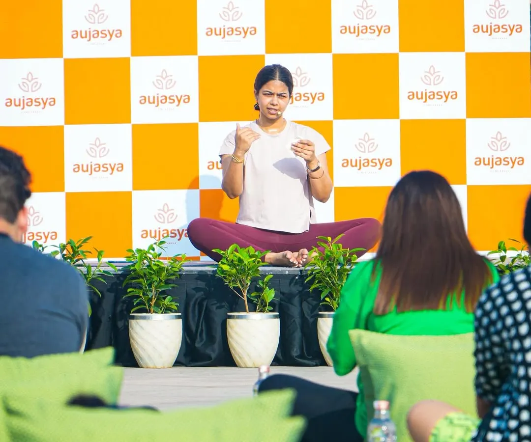 I love leading conscious talks and breathwork sessions for corporate teams. Here I am guiding a group through simple techniques to manage stress, set against the backdrop of a wellness event for the brand Aujasya.