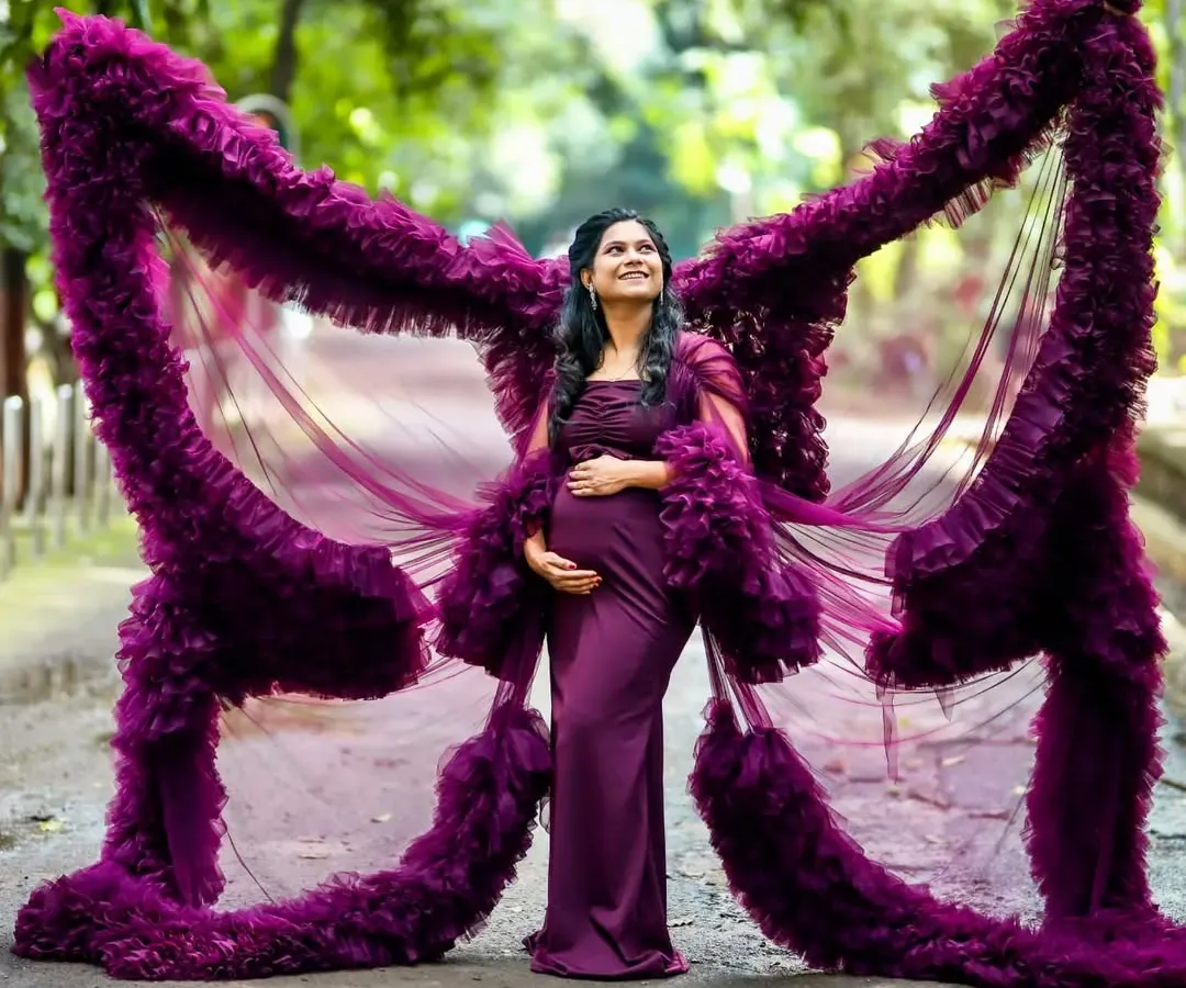 Feel like a goddess in my signature butterfly-effect maternity gown. The dramatic ruffled wings create a stunning silhouette that celebrates your journey to motherhood. This deep purple gown is a favorite for outdoor maternity shoots, adding a touch of royalty and magic.