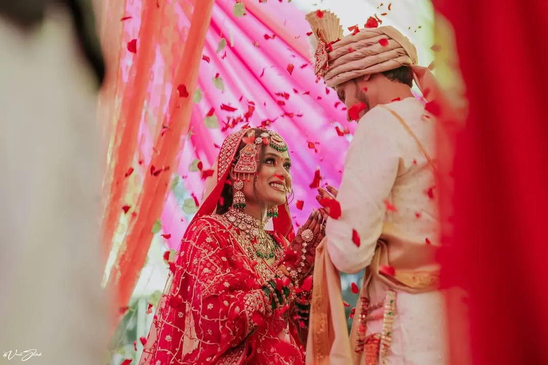 A perfect candid moment from a Maharashtrian wedding ceremony. I love capturing these genuine interactions, like the bride's joyful smile as flower petals rain down, creating a memory that feels as happy as the moment itself.