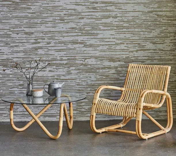 Here is a classic rattan lounge chair paired with a matching coffee table that has a durable glass top. This design highlights the gentle curves and expert binding I use to create comfortable and timeless pieces for any living space.