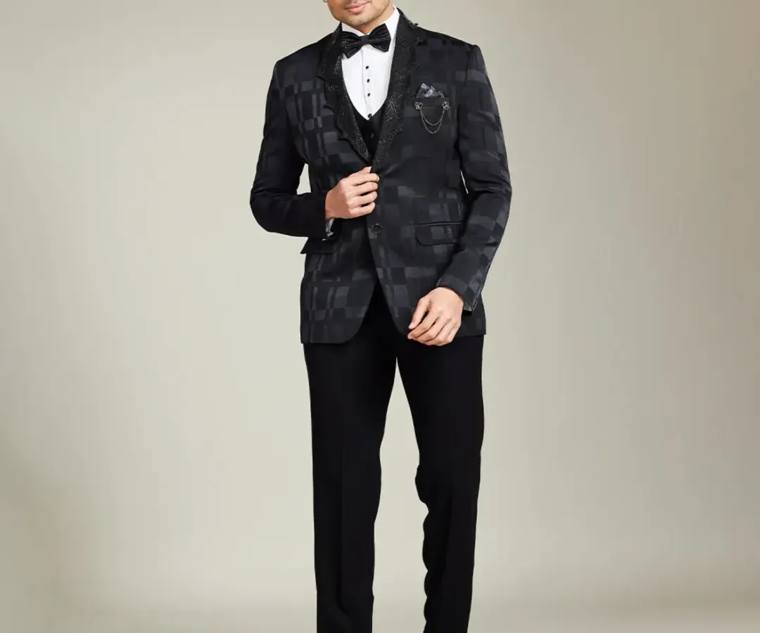A bespoke tuxedo is the ultimate statement of class. This full-length shot shows the impeccable fit and sharp silhouette of a custom-patterned black three-piece suit, designed for black-tie events or a sophisticated groom's reception look.