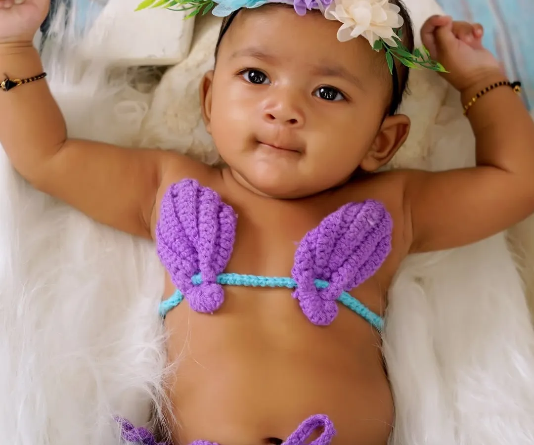 I love getting creative with themed baby photoshoots. For this little one, we created a magical mermaid theme. This close-up shot shows the adorable details, from the hand-crocheted mermaid costume to the floral headband, all while ensuring the baby is comfortable and safe.