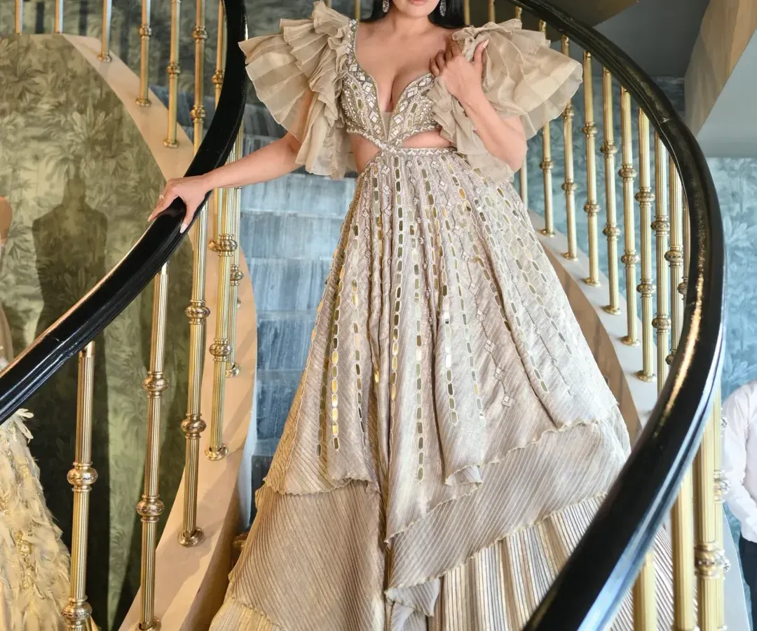 For a red carpet or a grand celebration, I focus on creating a look that is pure magic. This stunning couture gown with its dramatic ruffled sleeves, intricate cutouts, and shimmering fabric is all about making an unforgettable entrance. Styling for such events is about capturing a feeling of timeless elegance.