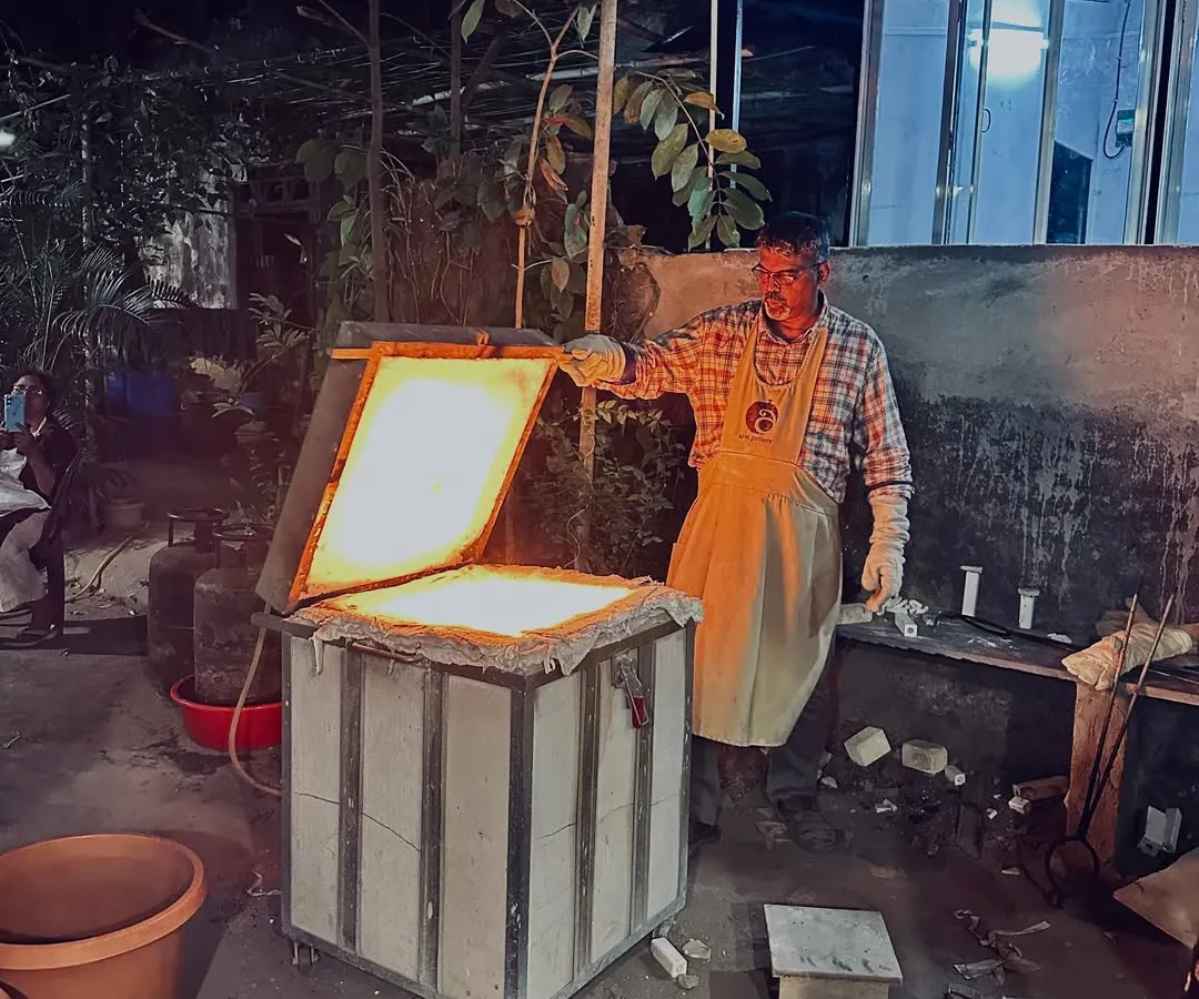 This is the moment of transformation. I am opening the kiln during a Raku firing session, where intense heat and sudden cooling create beautifully unpredictable patterns. It's a process that's as much about letting go as it is about control.