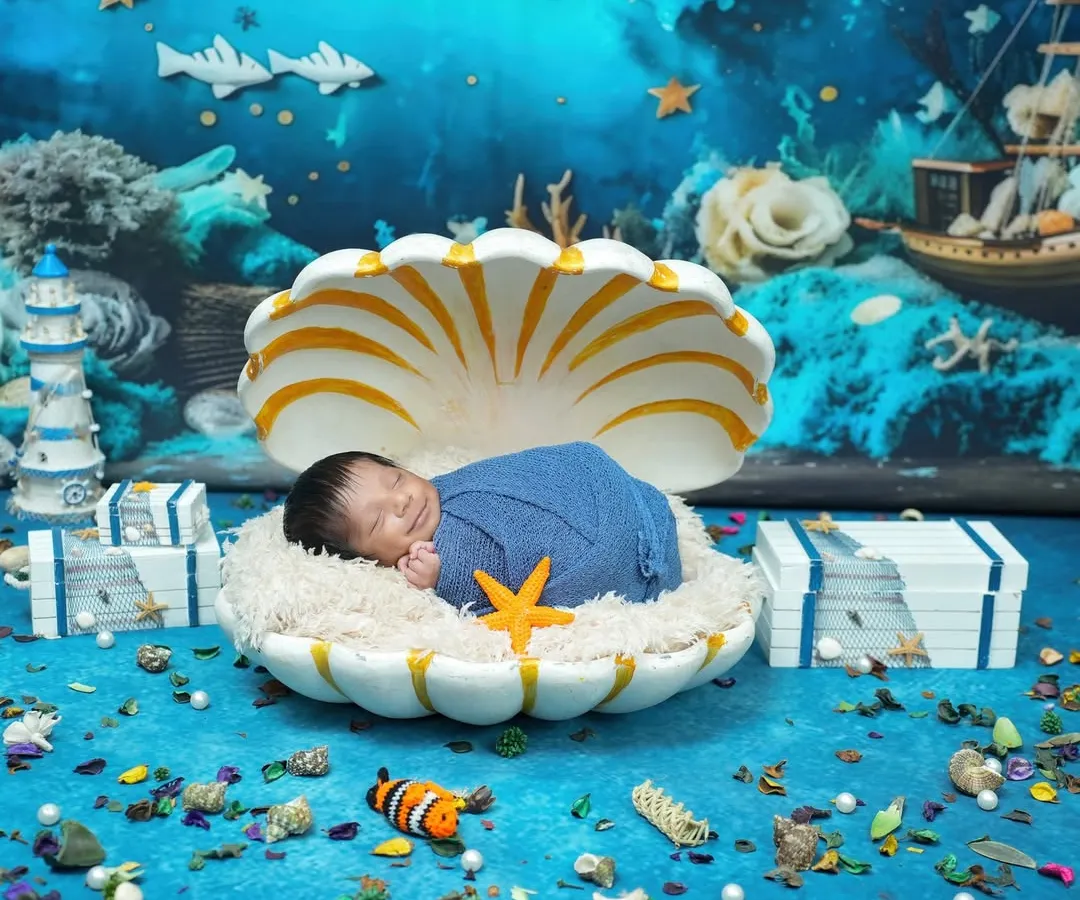 Your little one is a precious pearl, and we love creating magical worlds for their first photoshoot. This newborn session features an imaginative underwater theme, with the baby sleeping peacefully in a giant seashell. Every detail, from the coral backdrop to the tiny starfish, is designed to create a whimsical and unforgettable portrait.