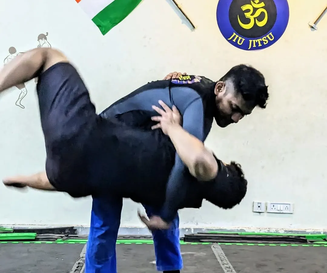 Grappling is the core of what we do. Here, I'm demonstrating a hip toss, a fundamental wrestling technique that is crucial for controlling an opponent in MMA and self-defense situations. Understanding how to transition from standing to the ground is a game changer.