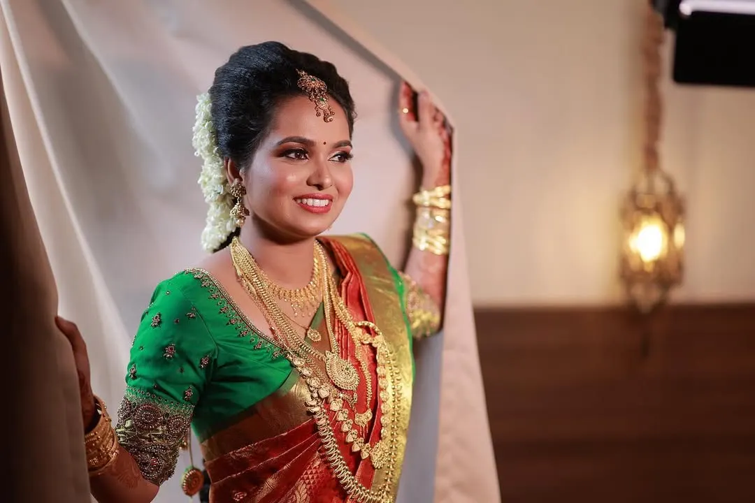 A picture of pure joy. For this South Indian bride, I created a classic look with a dewy base, defined eyes, and a bright smile. The makeup is designed to complement her beautiful Kanjeevaram saree and traditional gold jewellery, ensuring she looks timeless.