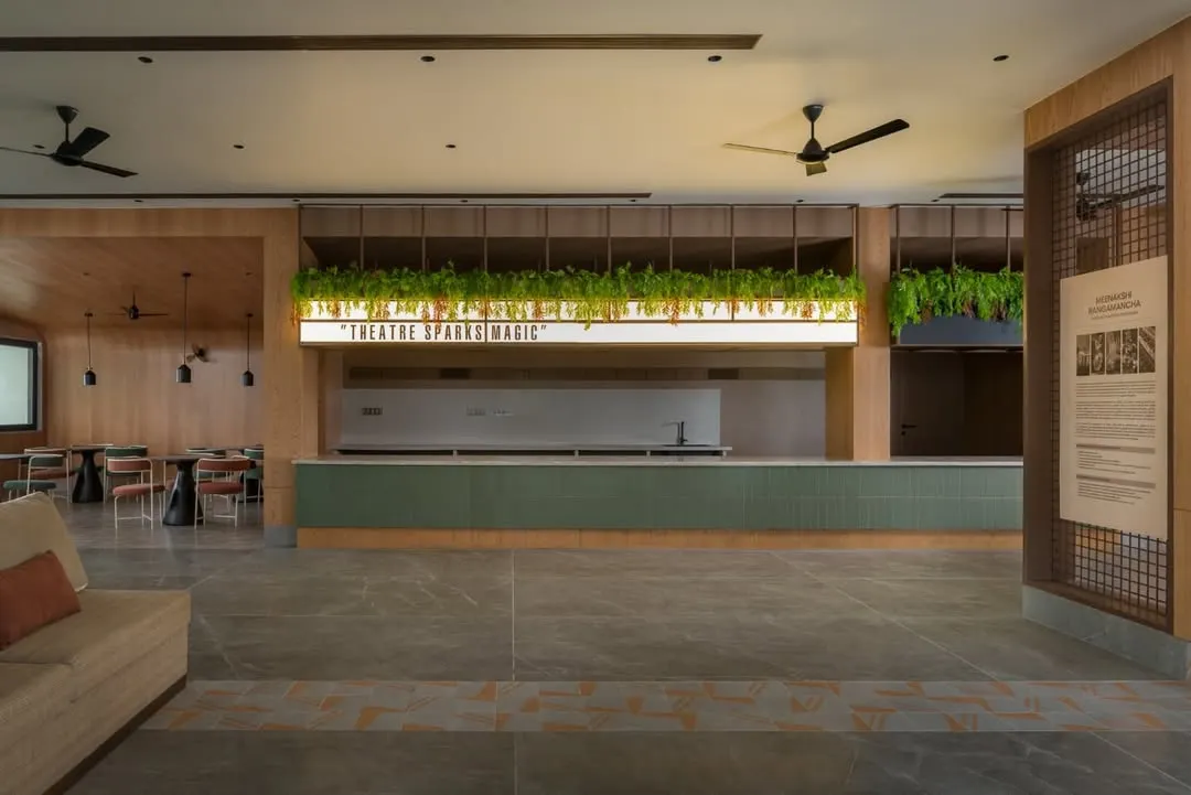 The lobby of the Sri Kumaran School auditorium is designed as a welcoming space for art and culture. We used warm wood paneling, lush greenery, and a prominent light feature to create an inviting atmosphere that encourages guests to linger and connect before a performance.