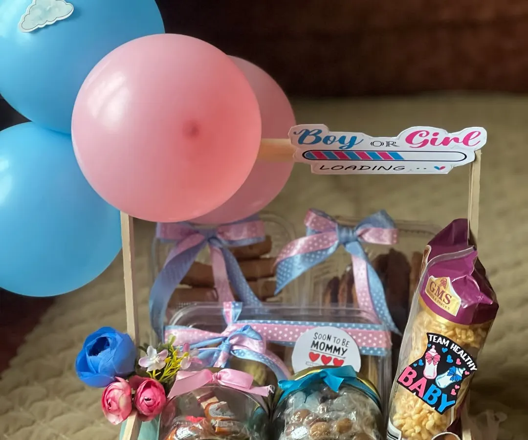 A perfect hamper for a gender reveal party. I use pink and blue themes with balloons and fun stickers to build excitement, packing the crate with delicious cookies and snacks for everyone to enjoy during the celebration.